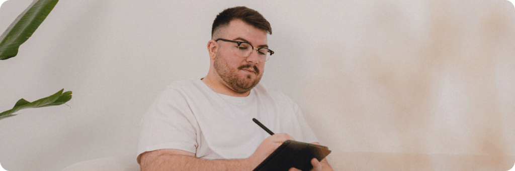 Ross Powell, co-founder of The Business Tea, making strategic marketing notes on a tablet in preparation for a marketing consultancy session with a client.