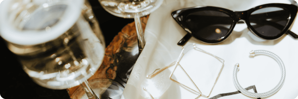 Stylish sunglasses, jewelry, and champagne glasses on a luxurious table setting