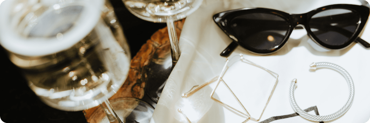 Stylish sunglasses, jewelry, and champagne glasses on a luxurious table setting